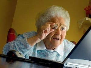 old lady adjusting glasses computer